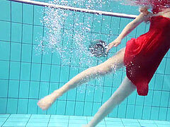 crimson clad teenage swimming with her eyes opened