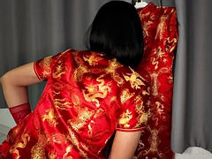 Transvestite sisk masturbates in red Chinese dress