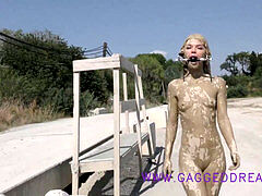 lovely nubile walking ball-gagged outdoor after a mudbath